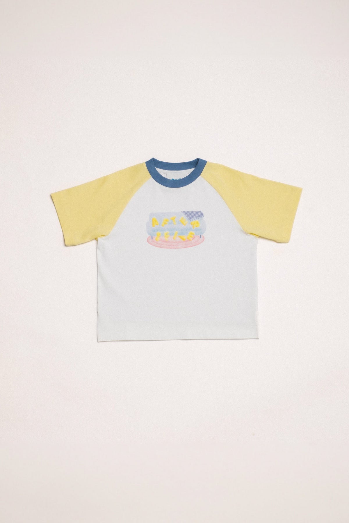 In Reverie Tee in white with yellow raglan sleeves and a ribbed blue neckline